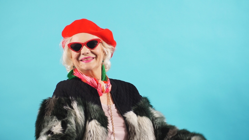 Optimistic old woman doesn't think about her age, oldness. Isolated blue background. lifestyle, leisure. happiness Royalty-Free Stock Footage #1038953273