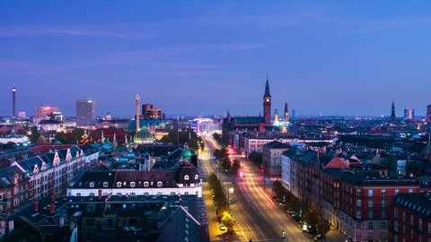 Copenhagen, Denmark. Aerial view of city center at sunrise in Copenhagen, Denmark. Time-lapse with car traffic and illuminated buildings, park Tivoli and City hall in the morning, zoom in