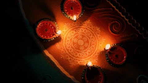 celebration of Indian festival Diwali - oil lamps lit on colorful rangoli