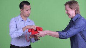 Young businessman giving telephone to stressed Asian businessman looking angry - Powered by Shutterstock - Get 15% off with code: PIKWIZARD15