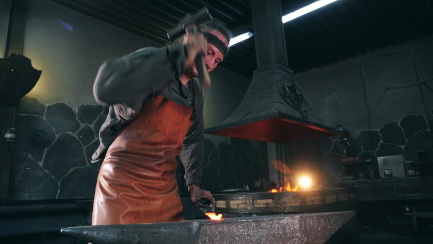 Workshop and the craftsman hammering iron