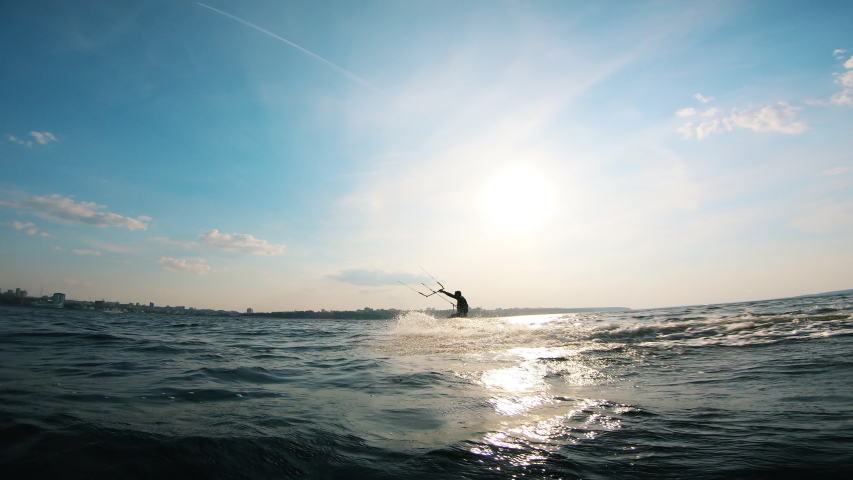 A kitesurfer splashing water while riding a board. Kite surfer kiteboarding. Royalty-Free Stock Footage #1038971459