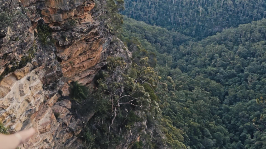Slow Motion 120fps Pull Back Shot of Young Female Hiker on Top of Cliff Pointing Finger to Scenic Valley in Blue Mountains National Park Australia