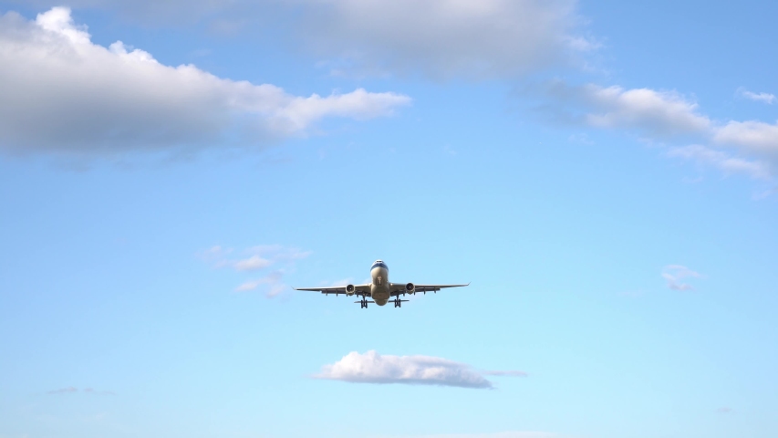 Modern large plane flies overhead. Beautiful blue sky and white fluffy clouds in the background. The aircraft takes off, landing. Day time. Ultra HD stock footage
 Royalty-Free Stock Footage #1038975014