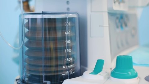 Close up view of anaesthesia machine ventilator and patients monitor inside the operating room. Close-up, blurred background, blue light.