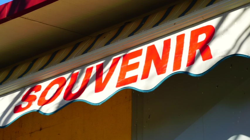 Souvenirs written on a shop curtain moved by the wind in the morning sun