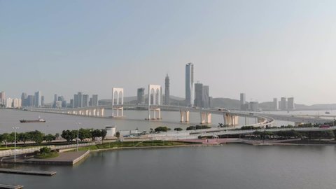 Drone approach shot of traffic crossing Sai Van Bridge in Macau with mainland China skyscrapers in background