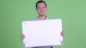 Happy Asian businessman holding white board - Powered by Shutterstock - Get 15% off with code: PIKWIZARD15