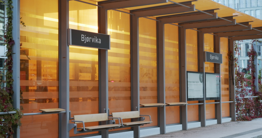 Cinema 4K medium gimbal shot with parallax motion of new orange bus, train and tram station in the new Bjørvika Opera quarter project, in Oslo Norway.