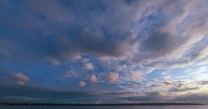 Time-lapse video panorama of the sunset over the ocean. Clouds running across the sky, the silhouette of forest and ships on a summer evening