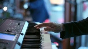 A wedding band keyboard player playing an electronic piano on stage. Close up shot of a synthesizer artist hand and the keyboard with selective focus - Powered by Shutterstock - Get 15% off with code: PIKWIZARD15