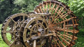 Working and turning old mill wooden water wheel in Huanglong Yellow Dragon Cave scenic area, Zhangjiajie, Hunan, China
