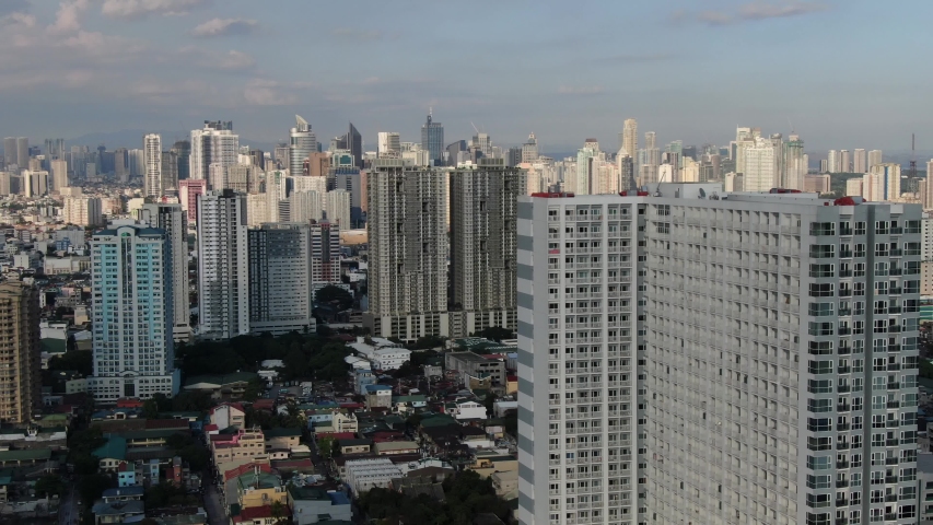 Aerial side view flying over the Manila City skylines,showing biggest skyscrapers around then big city
