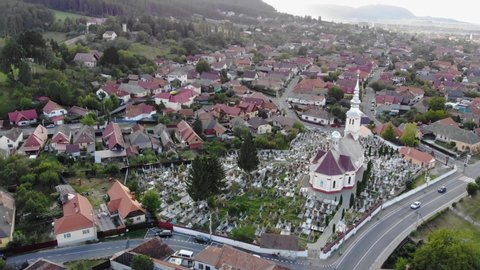 Aerial view of a church in the middle of a graveyard in Sacele, Brasov, Romania at sunset