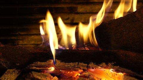 Close up Footage of real burning firewood in cozy open fireplace at cabin or home in Winter Christmas and relaxation video background concept.
