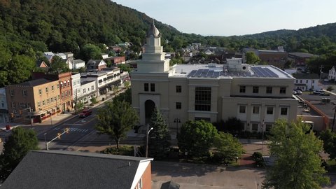 Low aerial dolly to the left of Berkeley Springs, West Virginia in the morning on a summer day.