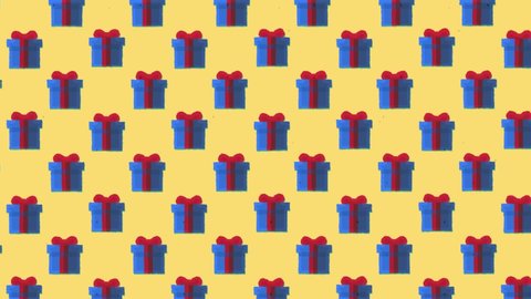 Animation: a repeating pattern of a blue gift box with a red ribbon,ing to the upper left angle of the screen, over a yellow background.