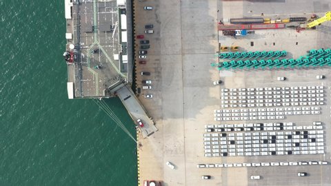 Aerial view of the huge ro-ro ship loading hunderds of cars for import export around the world. New cars produced running into Automotive container carriers ship. Transportation oversea business.