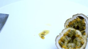 Cutting passion fruit fruit with a knife on a white background