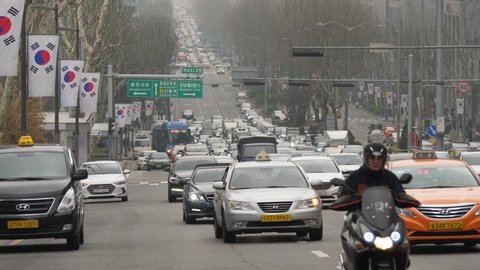 SEOUL, SOUTH KOREA - MARCH 29, 2018: Morning traffic at major street of Seoul city, fine telephoto perspective. Personal cars and taxis ride along Eonju-ro, Yeoksam neighbourhood of Gngnam district