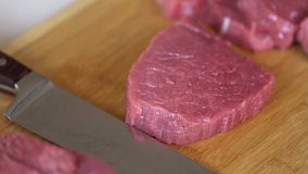Beef tenderloin cut in slices with a big kitchen knife . Close shot 4K camera. Chef's Table and cooking show inspired footage