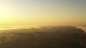 4k Video of the dawn over the village covered with morning fog. The sun's rays cut the fog beautifully.
