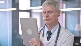 The Portrait Shot of Middle Aged Doctor doing Video Chat on Tablet pc