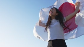 Proud and Excited Japanese FAN holding Flag of Japan cheering for her country. Shot on Red Camera. Slow motion. Patriot and sports fan concepts. Test space for COPY. - Powered by Shutterstock - Get 15% off with code: PIKWIZARD15