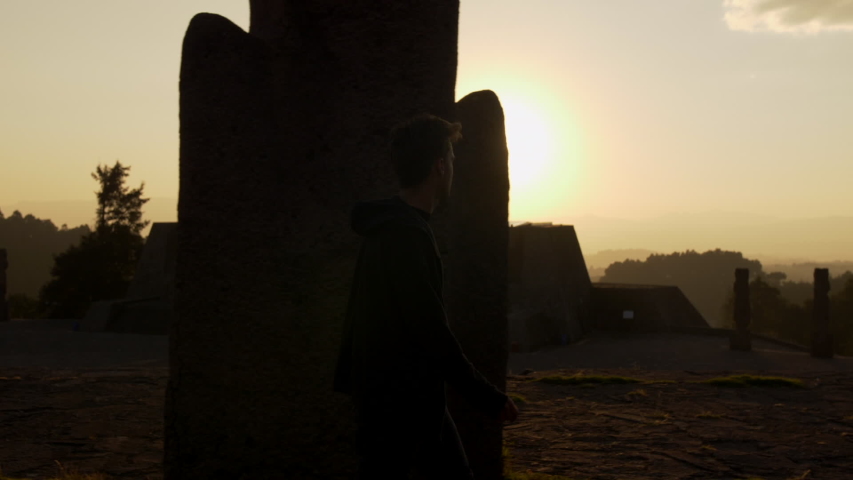 Slow motion shot of tourist walking in front of impressive ruins at San Miguel De Allende City in Mexico during sunset.