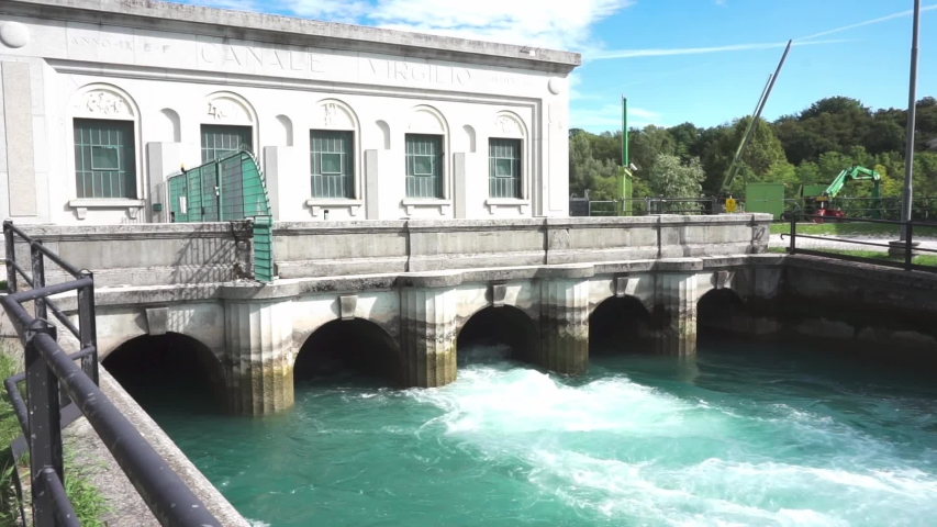 Static shot of a water flow regulator house with a turquise river.