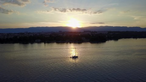 Breathtaking sunset on Lake Geneva, Switzerland. Aerial view over sailing boats taken by drone.