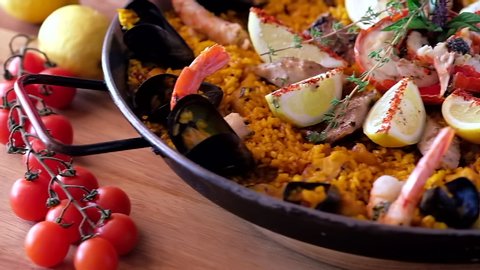 Close up view in big shallow pan prepared seafood paella beautifully decorated and ready for eating, food in motion concept