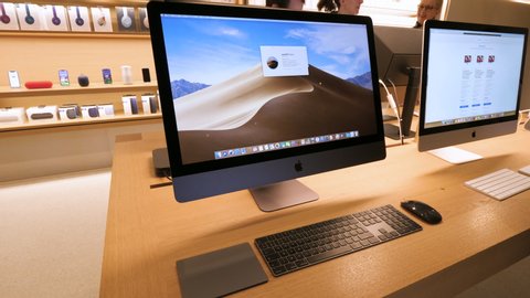 Paris, France - Circa 2019: Apple Computers iMac pro professional workstation computers inside Apple Store with customers in background and MacOS Mojave operating system on screen