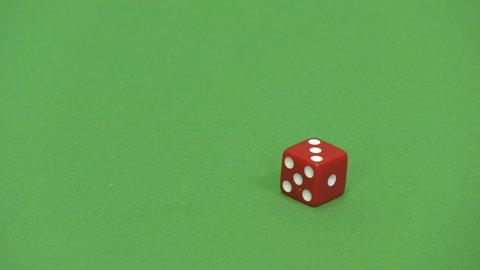 Green screen shot of a red dice rolling 3