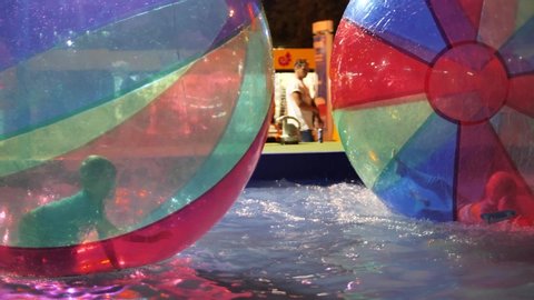 Russia, Anapa, August 4, 2019. Children play and fun in the pool inside large multi-colored plastic balls on the water.