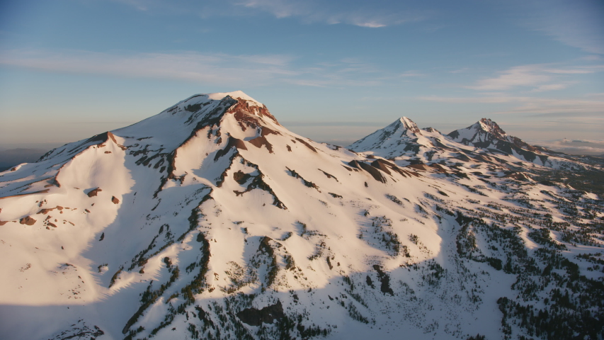 Cascade Mountains, Oregon circa-2019. Aerial view of Sisters Mountains. Shot from helicopter with Cineflex gimbal and RED 8K camera.