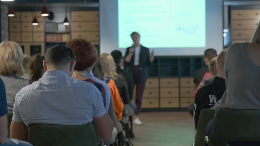 Audience listens lecturer at workshop in conference hall