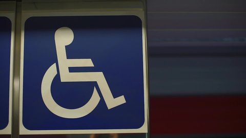 sign of a disabled person at the airport drawn white red on a blue background