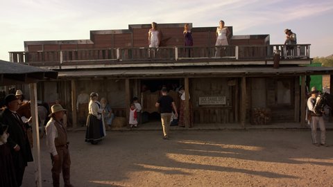 San Diego , CA / United States - 02 18 2019: Period style reenactment of wild west scene in front of saloon. Gun fight & general people in wild west costumes walking and going about their roles.