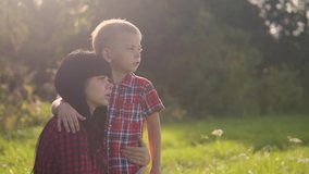 happyfamily mother's day the nature slow motion video teamwork outdoors . son lifestyle boy hugs mom girl outdoors shows the distance with his hand sunlight cute video care. mother and son cuddle