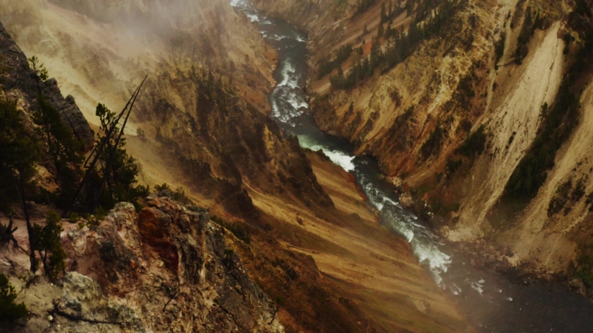 Grand Canyon in Yellowstone National Park, aerial view of Yellowstone lands, mountains in a fog, fast river flow between mountains 