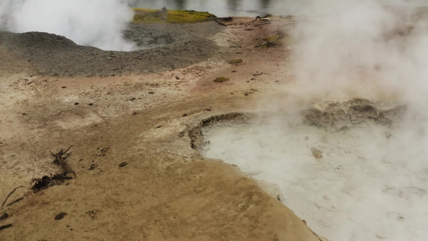 mud pots in Yellowstone National Park, aerial view of Yellowstone lands, hills and mountains, steaming geysers