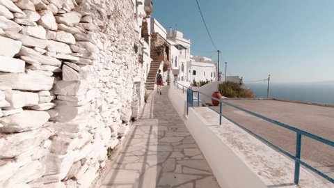 Camera Following Tourist Walking in Tinos Island on a Beautiful Sunny Day. Slow Motion.
