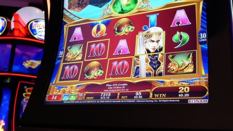 COQUITLAM , British Columbia / Canada - 06 12 2018: Coquitlam, BC, Canada - June 12, 2018 : Motion of people playing slot machine inside Casino focuses on-screen with 4k resolution