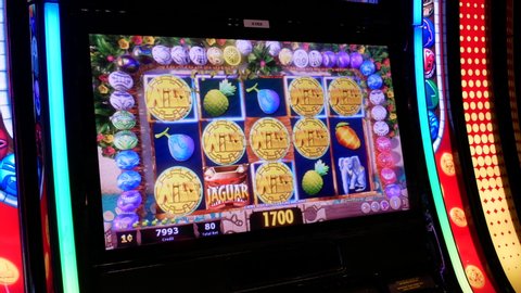 COQUITLAM , British Columbia / Canada - 06 12 2018: Coquitlam, BC, Canada - June 12, 2018 : Motion of people playing slot machine inside Casino focus on screen with 4k resolution