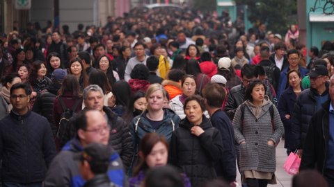 SHANGHAI - MARCH 18, 2018: Mass of unidentified people on popular pedestrian street at Chinese city, medium telephoto shot of crowd. Citizens and domestic tourists stroll along famous Nan Jing Lu