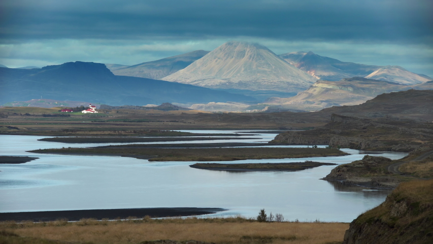 Scenic Icelandic river valley farm under mountains and low clouds.mov
