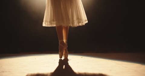 Beautiful ballet choreographer having a performance on theatre stage, dancing while spotted by bright light - arts concept 4k footage