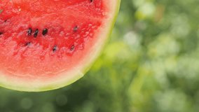 Close-up of half a juicy ripe watermelon, fresh juice flows down from fruit. Tasty healthy food. 4K UHD video	