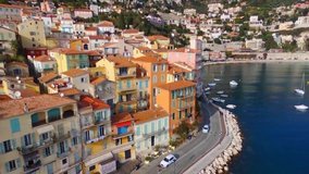 Beautiful panoramas are taken to the drone of narrow streets in a small European Italian French town by the sea. colored houses. Video in motion. Blue sky. French Riviera. Ancient houses and streets